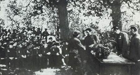 .И. Козлов (стоит у стола слева) вручает партизанам правительственные награды