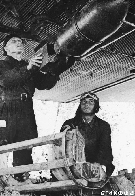 Борттехник И.П. Феоктистов и помощник борттехника В.В. Шуменко подвешивают бомбы к тяжелому ночному бомбардировщику